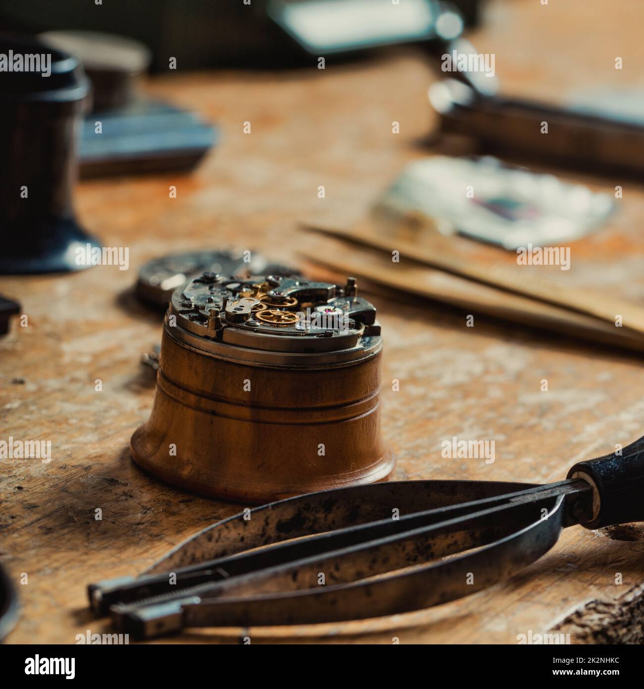 Alte Uhrenmechanik und Handwerkzeug auf einer Uhrmacherbank Stockfoto