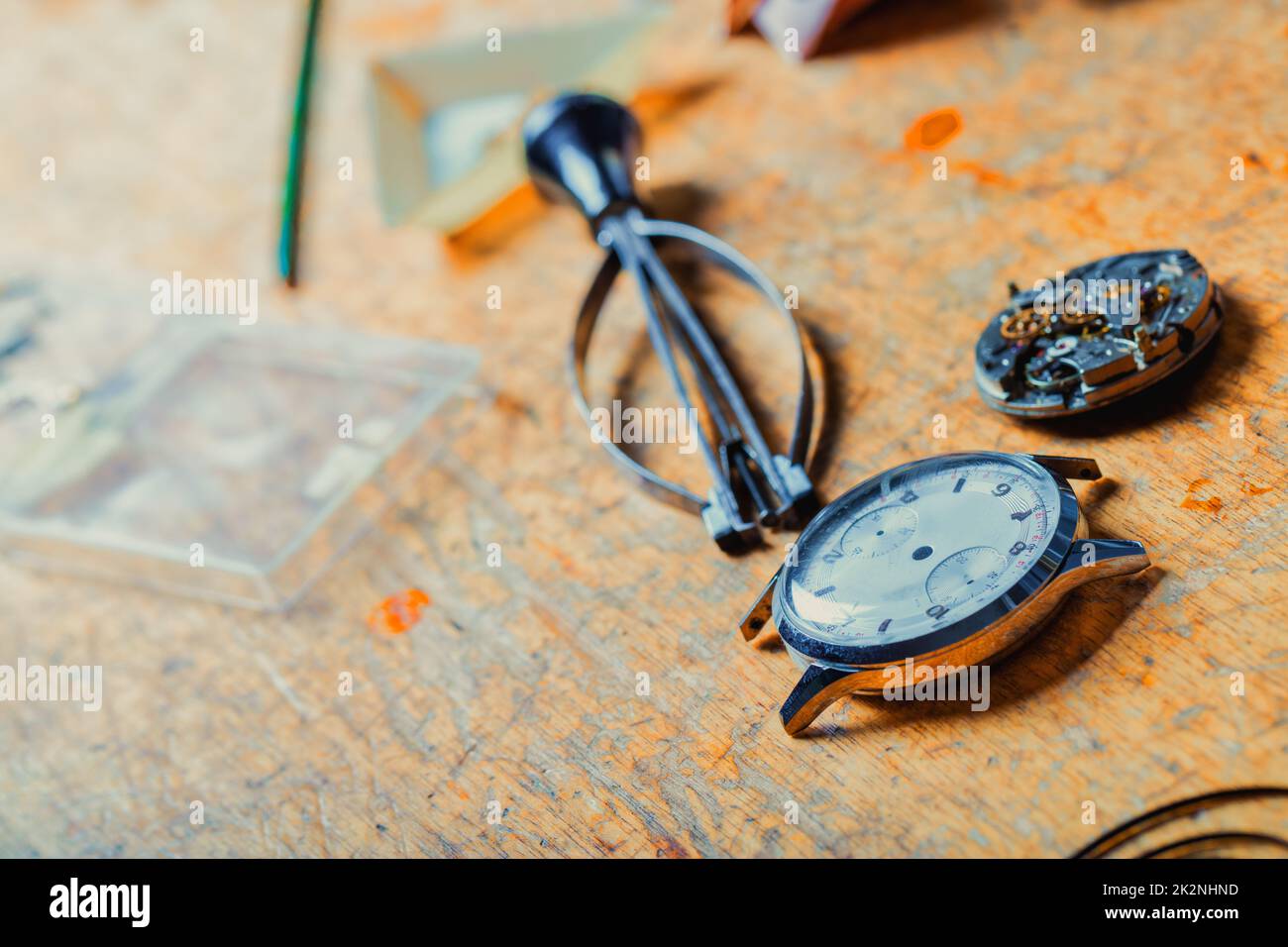 Armbanduhr und lose Mechanik, die auf einer Uhrmacherbank liegen Stockfoto