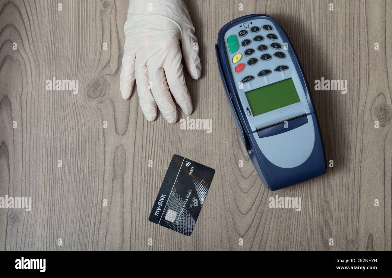 Einweghandschuh mit Bankkarte einreichen Stockfoto