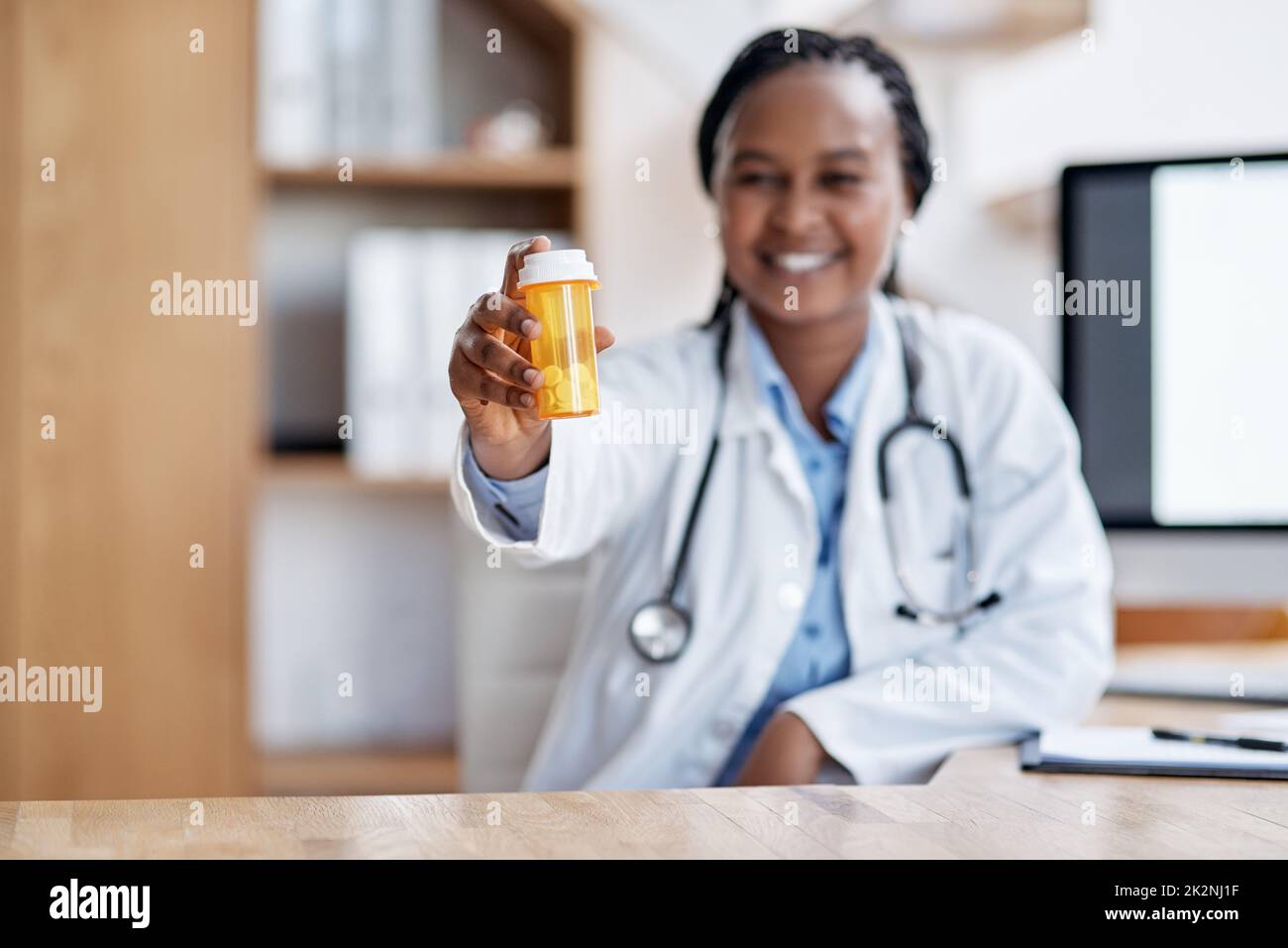 Nehmt diese und ruht Euch aus. Porträt einer jungen Ärztin, die eine Flasche Pillen in ihrem Büro hält. Stockfoto