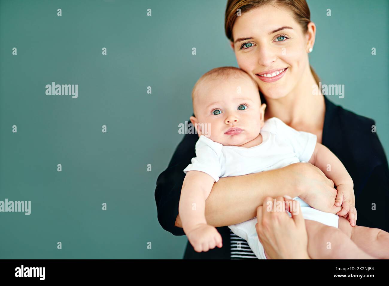 Eine Mutter und erfolgreiche Geschäftsfrau zu sein, ist so lohnend. Studioaufnahme einer erfolgreichen jungen Geschäftsfrau, die ihren entzückenden Jungen trägt. Stockfoto