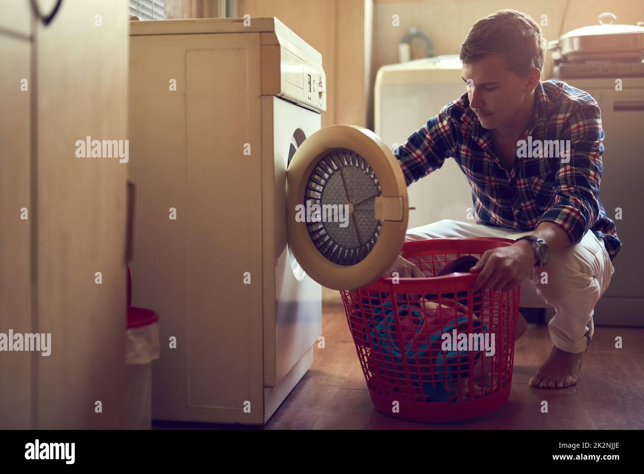 Sein Wäschespiel ist stark. Aufnahme eines jungen Mannes, der zu Hause Wäsche waschen soll. Stockfoto