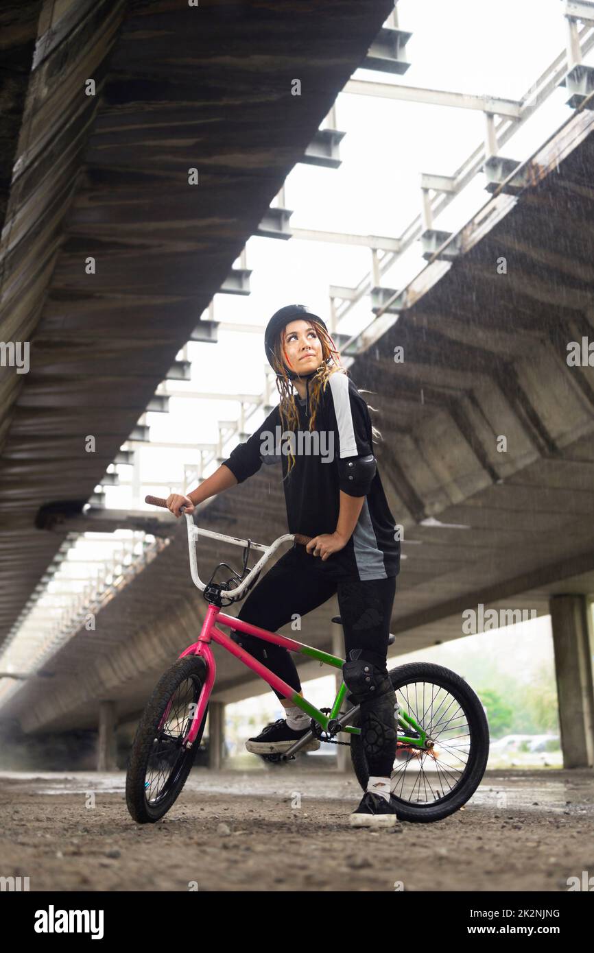 Junge Frau mit Helm und Freestyle-Bike Stockfoto