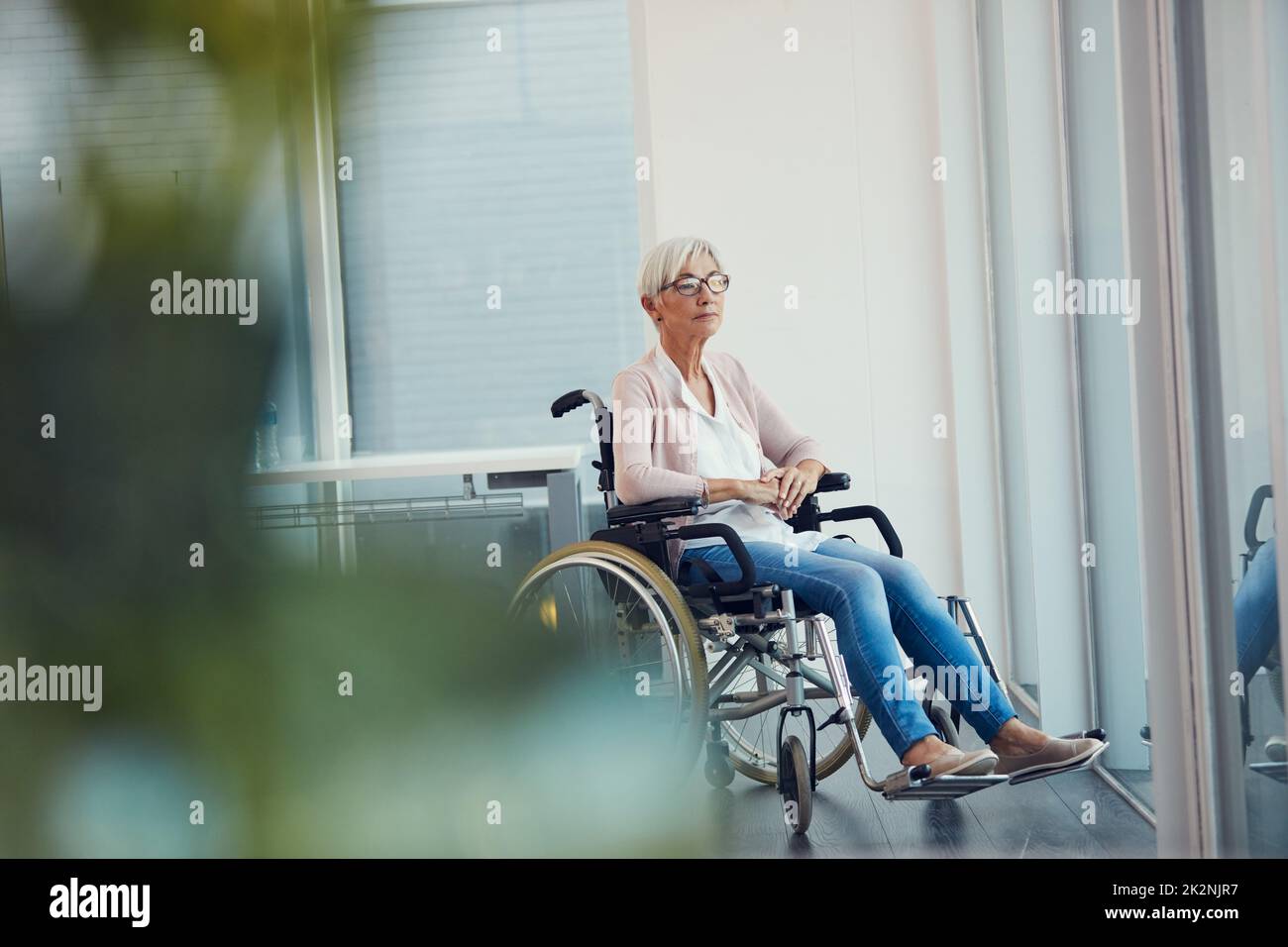 Wer wusste, dass itd so enden würde. In voller Länge eine ältere Frau, die nachdenklich aussieht, während sie in ihrem Rollstuhl in einem Altersheim sitzt. Stockfoto
