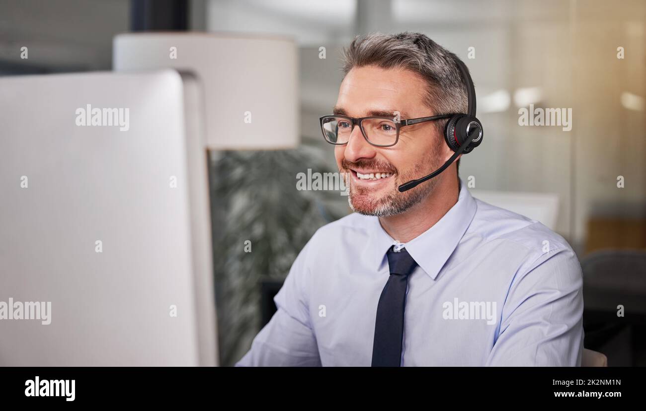Ich möchte, dass mein Rat den Kunden nie warten lassen wird. Aufnahme eines Callcenter-Agenten, der ein Headset trägt, während er an seinem Computer arbeitet. Stockfoto