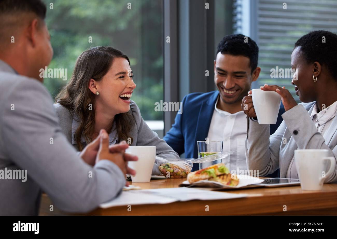 Wenn Sie zusammen lachen können, können Sie zusammenarbeiten. Aufnahme einer Gruppe von Kollegen, die in einem modernen Büro ein Meeting und Frühstück abhalten. Stockfoto