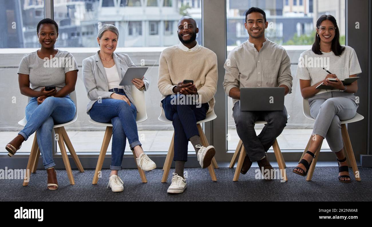 Was bringen Sie auf den Tisch. Aufnahme einer Gruppe von Geschäftsleuten, die drahtlose Geräte verwenden, während sie in der Schlange auf ein Interview warten. Stockfoto