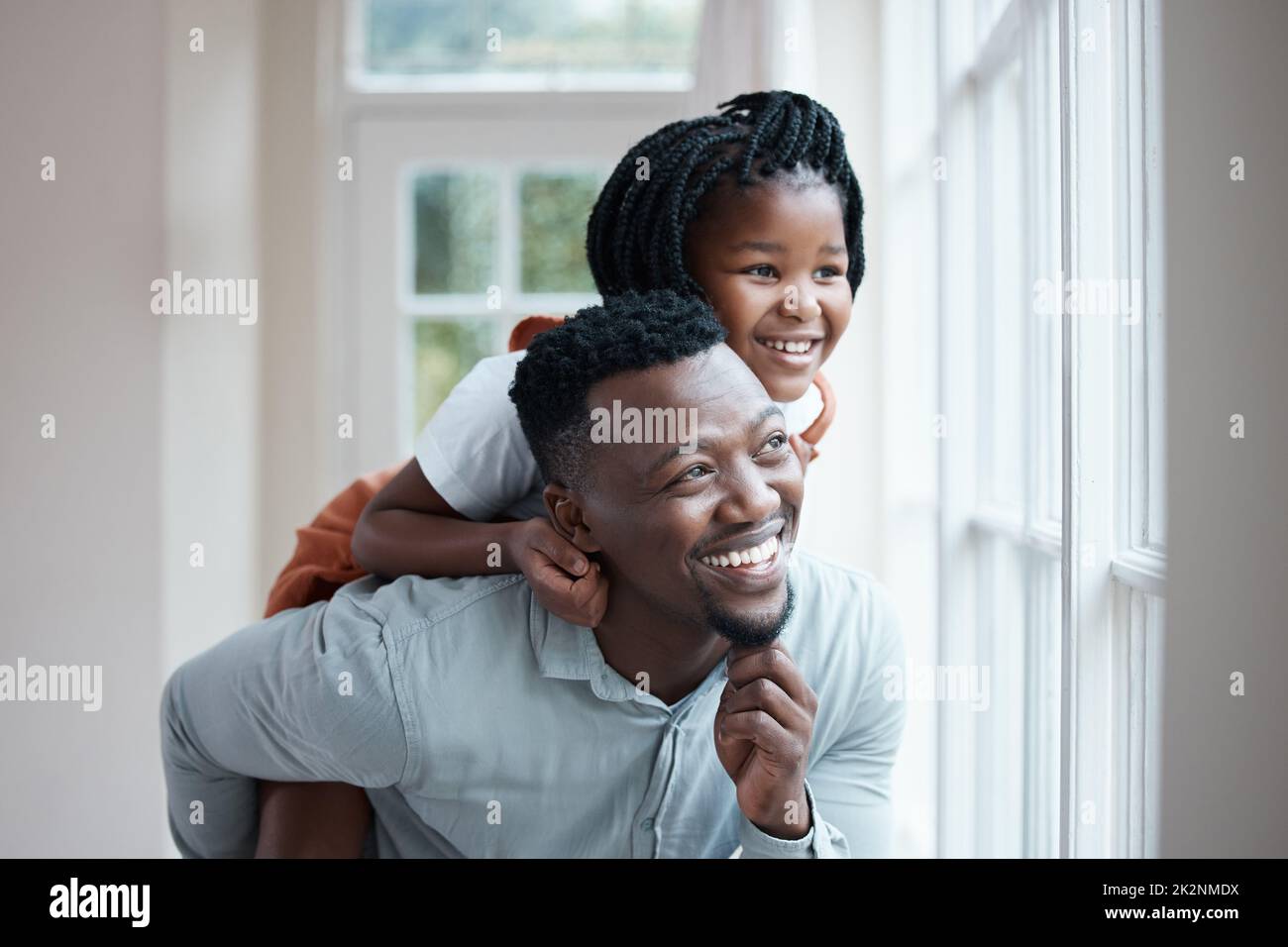 Sie sieht die Welt mit ihrem Vater anders. Aufnahme eines Vaters, der seiner Tochter zu Hause eine Huckepack-Fahrt gab. Stockfoto