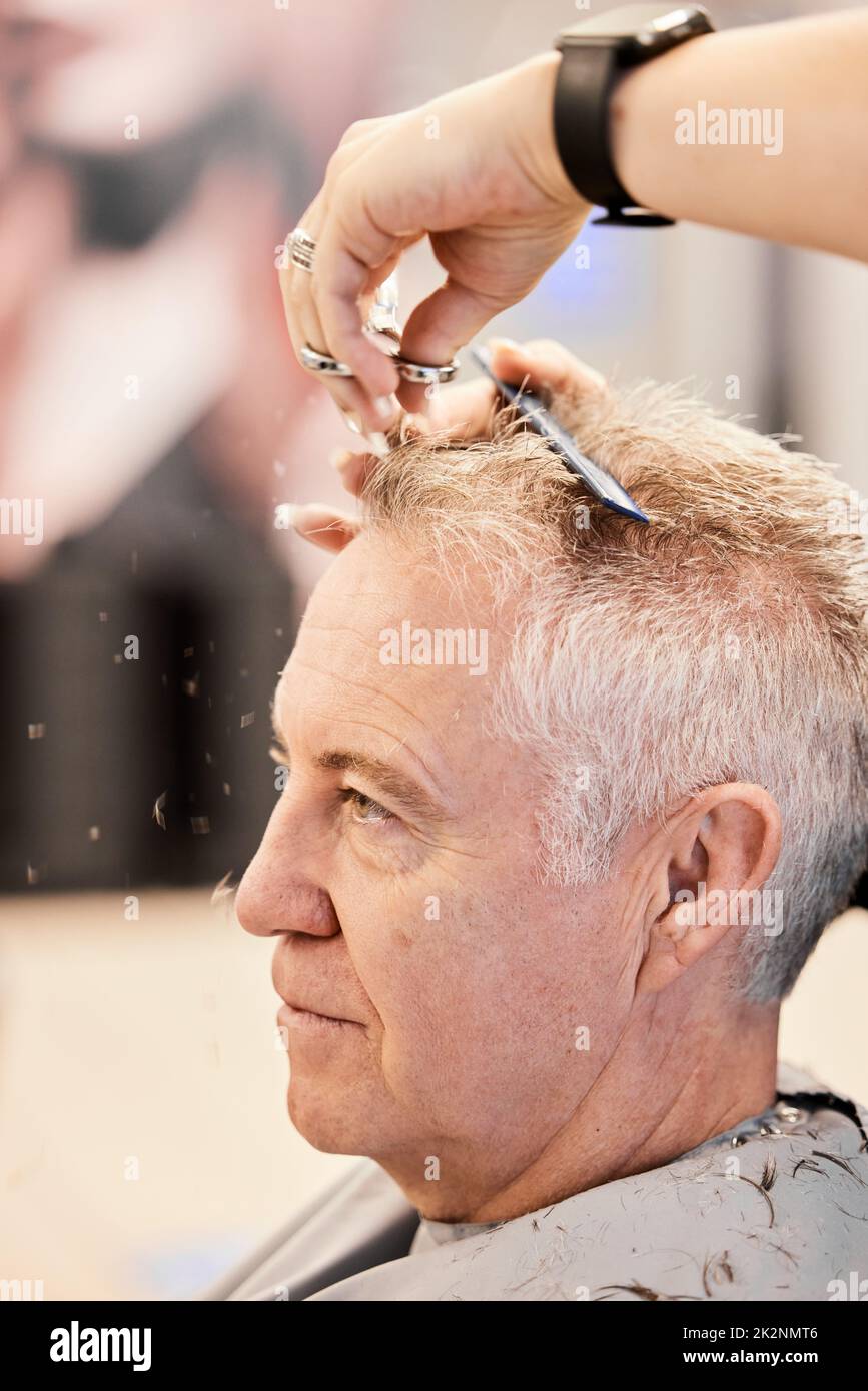 Ich bin gerade hier für eine Trimmung. Aufnahme eines reifen Mannes, der in einem Salon einen Haarschnitt bekommt. Stockfoto