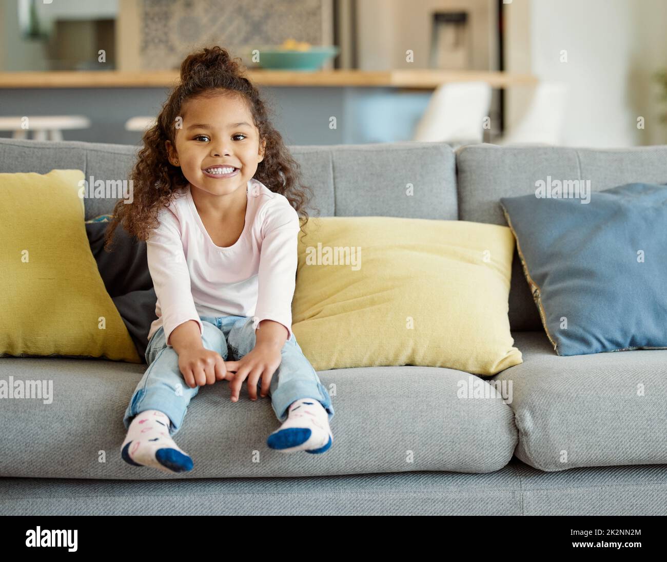 Sie liebt Wochenenden auf der Couch. Porträt eines kleinen Mädchens, das zu Hause auf dem Sofa sitzt. Stockfoto