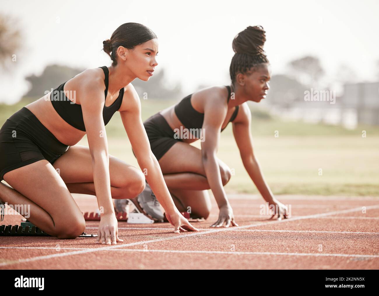 Es ist eins zu eins. Kurzer Schuss zweier attraktiver junger Athletinnen, die ihr Rennen auf einer Strecke starten. Stockfoto