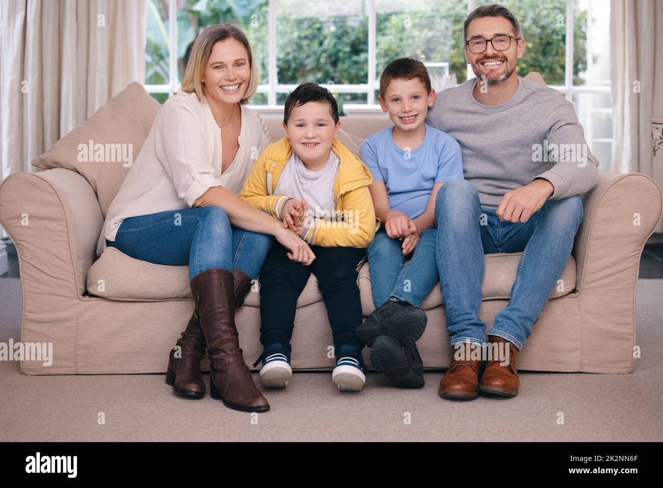 Die Wunder der Familie. Aufnahme einer jungen Familie, die sich glücklich auf dem Sofa zu Hause verbindet. Stockfoto