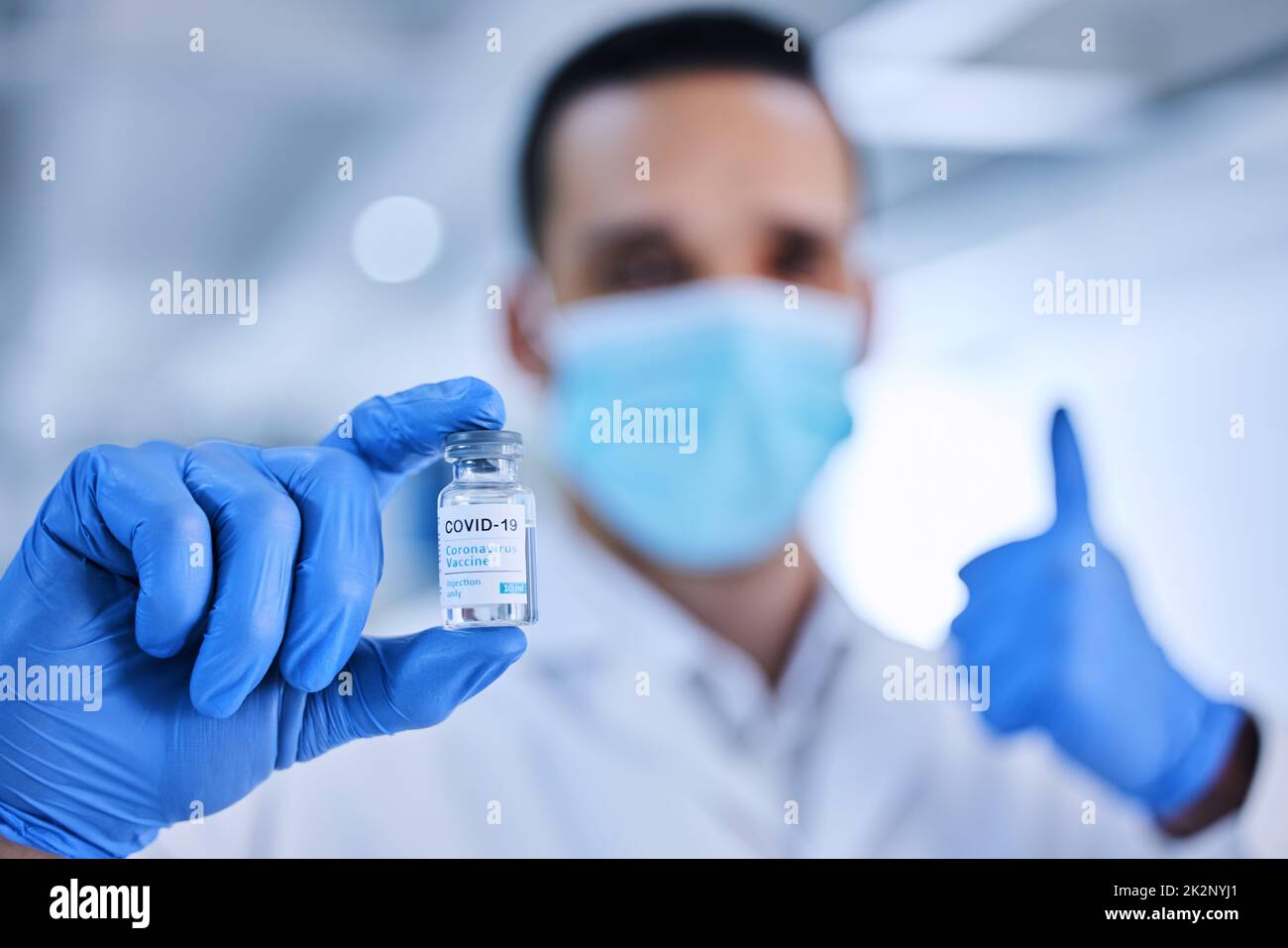 Ich unterstütze diesen Impfstoff voll und ganz. Zugeschnittenes Bild eines nicht erkennbaren männlichen Wissenschaftlers, der eine Flasche des Covid-19-Impfstoffs hochhält. Stockfoto