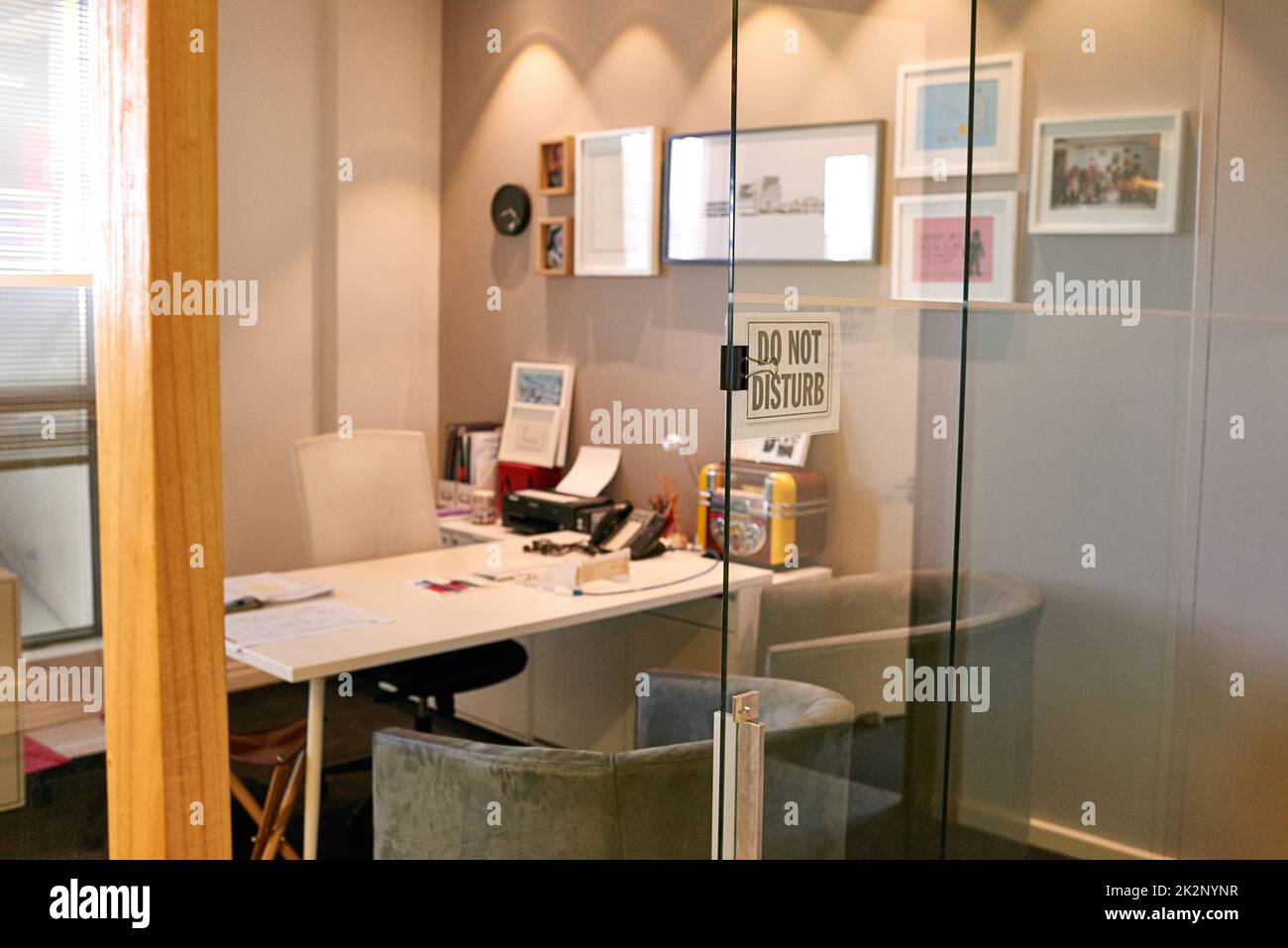Das Büro des Chefs. Aufnahme eines leeren Büros mit einem „Bitte nicht stören“-Schild im Fenster. Stockfoto