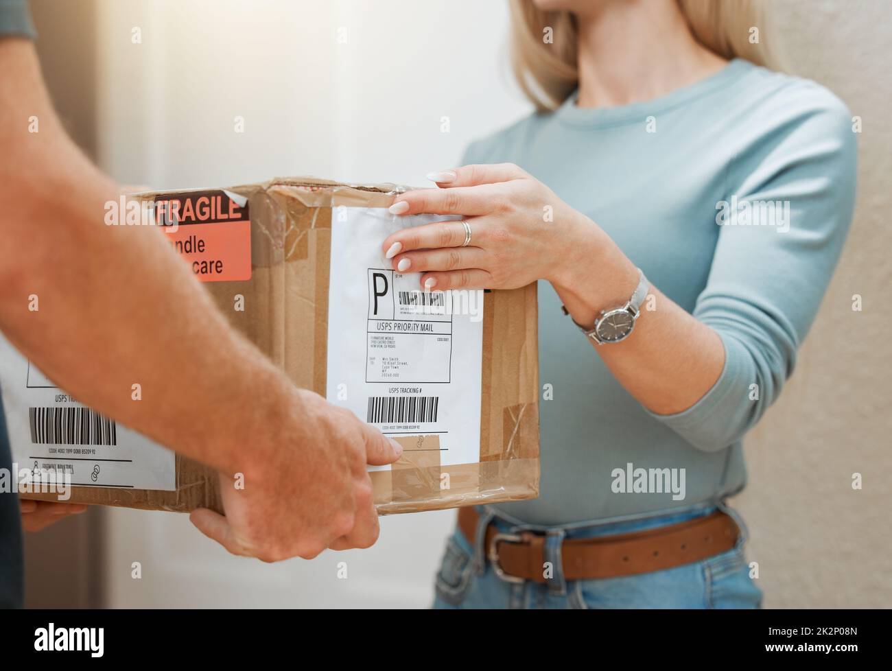 Lieferung Post sicher und pünktlich. Nahaufnahme eines nicht erkennbaren Mannes, der zu Hause einen Kunden beliefert. Stockfoto