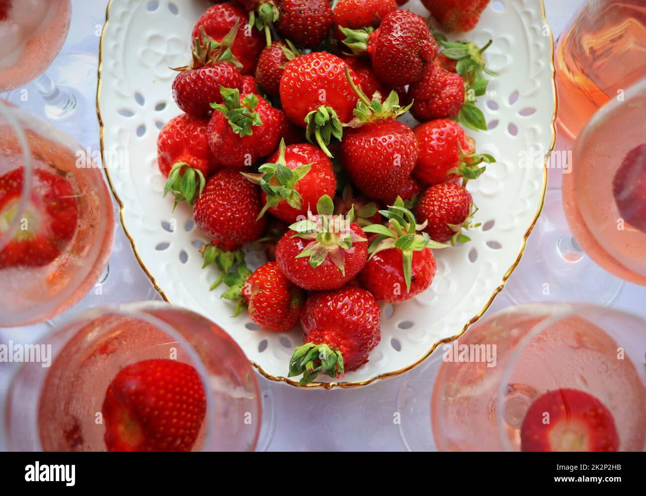 Rosenweingläser und leckere frische Erdbeeren auf weißem Hintergrund, Draufsicht Stockfoto