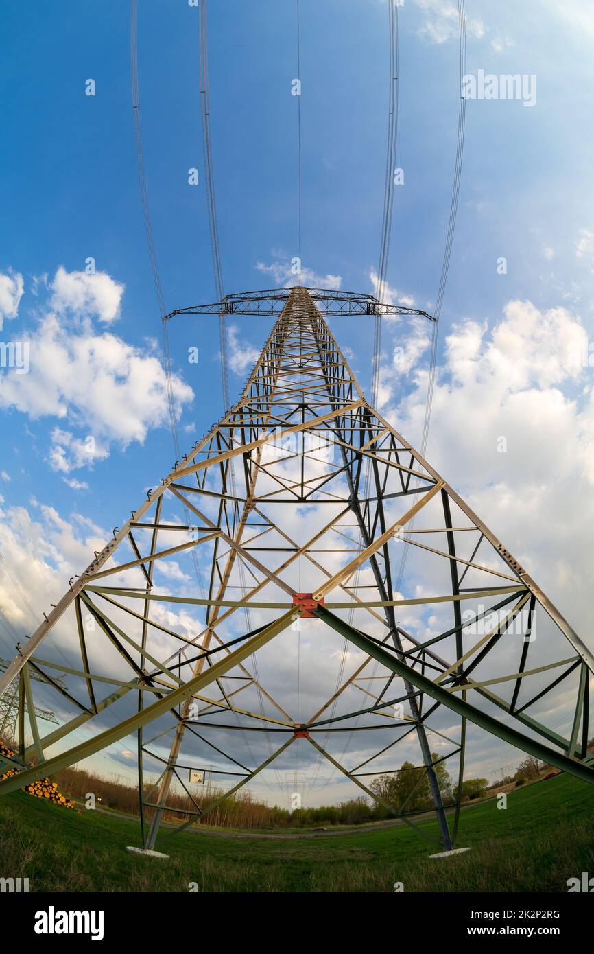 Metall-Stromübertragungsmasten auf einem Hintergrund des blauen Himmels. Fischaugenobjektiv. Stockfoto