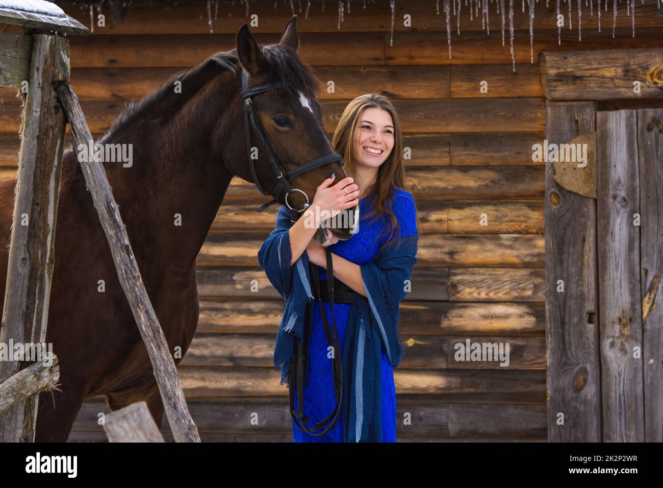 Glückliches Mädchen umarmt ein Pferd und Blick in die Ferne Stockfoto