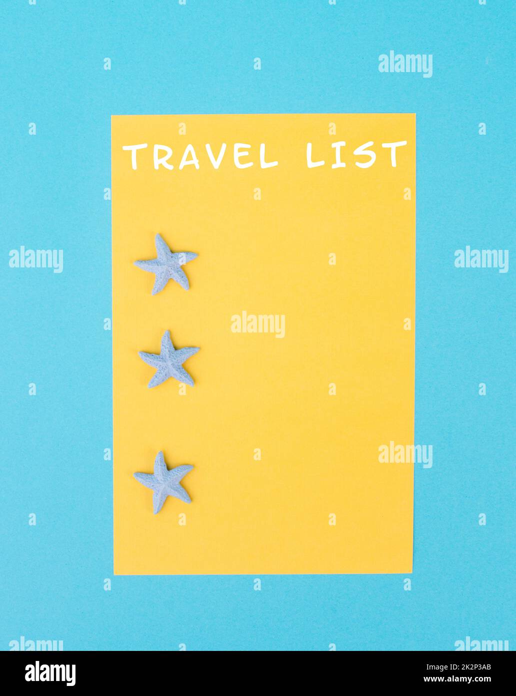 Travel list steht auf dem gelbfarbenen Papier, Seesternen, Ferienplan und Destination, Urlaubs- und Lifestyle-Konzept Stockfoto