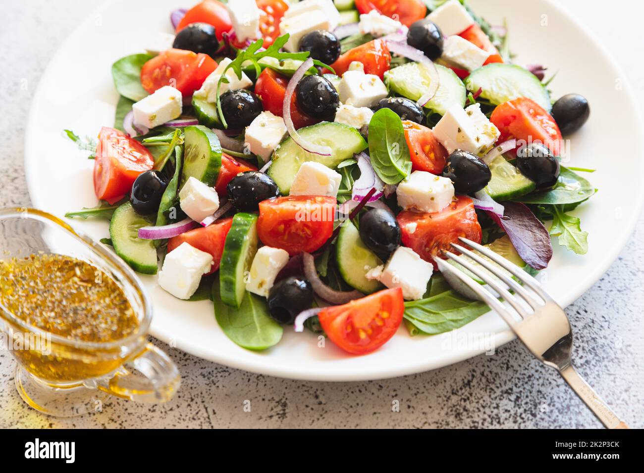 Griechischer Salat mit frischen Gurken, Tomaten, roten Zwiebeln, Fetakäse und Oliven mit Olivenöl. Gesundes Essen, Draufsicht Stockfoto