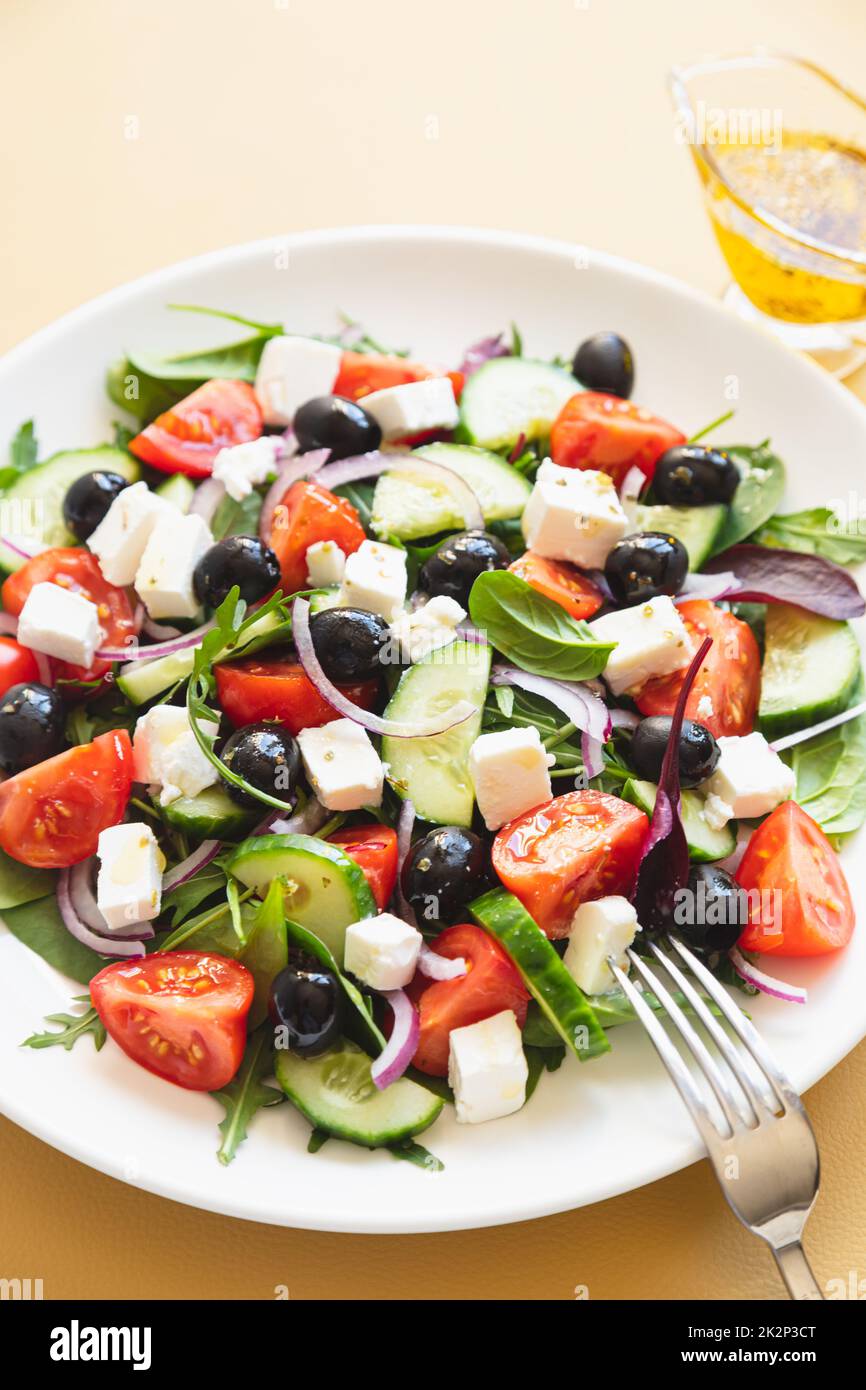 Griechischer Salat mit frischen Gurken, Tomaten, roten Zwiebeln, Fetakäse und Oliven mit Olivenöl. Gesundes Essen, Draufsicht Stockfoto