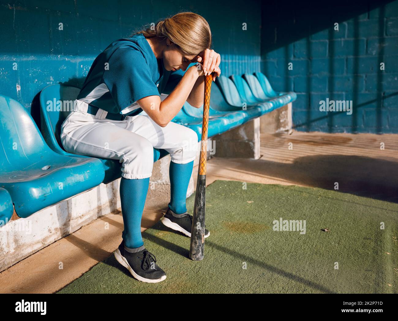 Baseballspieler, Sportbank und Sportlerin denken wütend an Spielverlust, während sie auf das Spiel warten. Frustriert, traurig und ernst Softball-Spieler Mädchen in Stockfoto