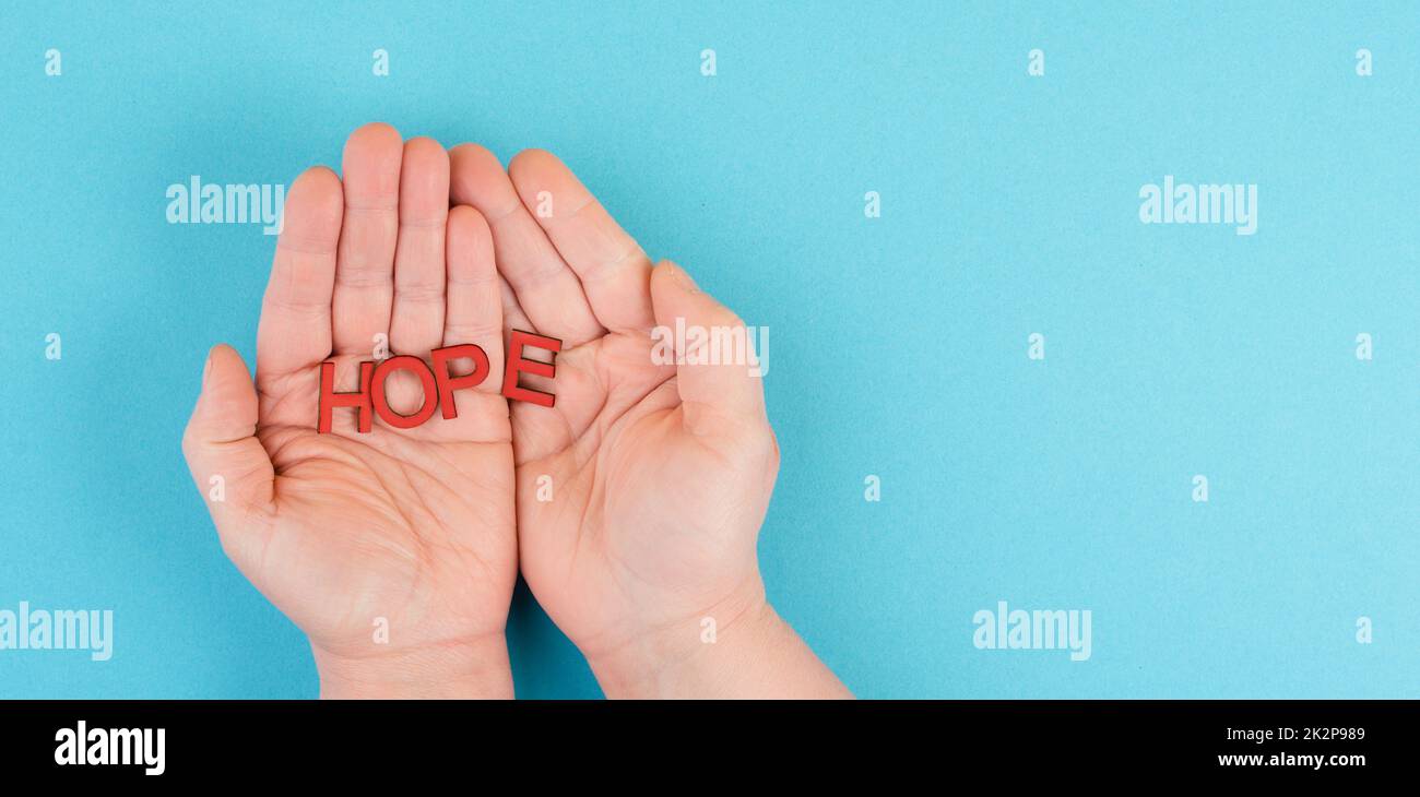 Das Wort Hoffnung in den Händen halten, Vertrauen und glauben Konzept, Vertrauen in die Zukunft haben, hoffnungsvoll positive Denkweise Stockfoto