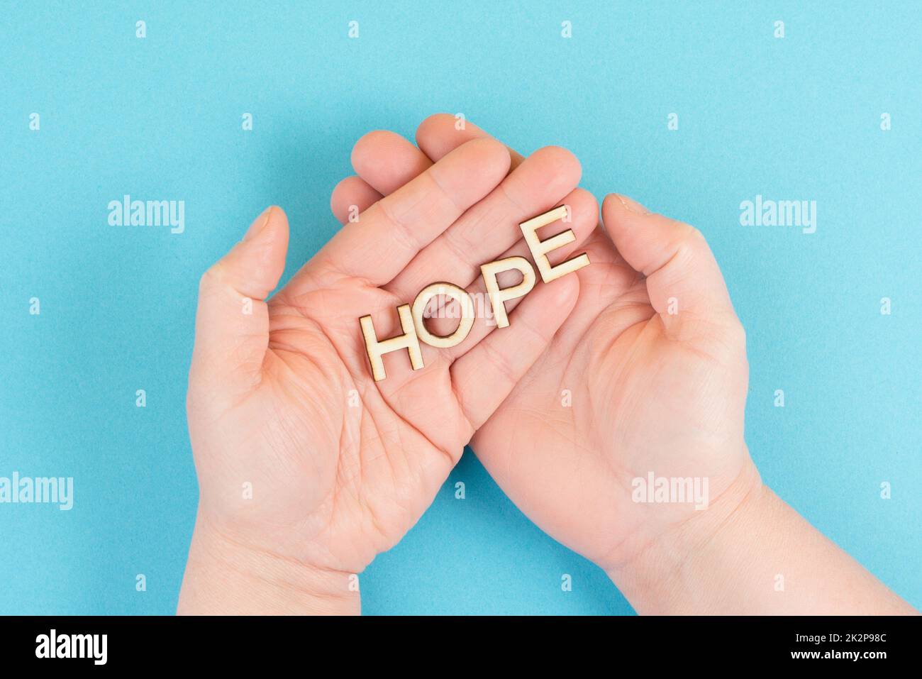 Das Wort Hoffnung in den Händen halten, Vertrauen und glauben Konzept, Vertrauen in die Zukunft haben, hoffnungsvoll positive Denkweise Stockfoto