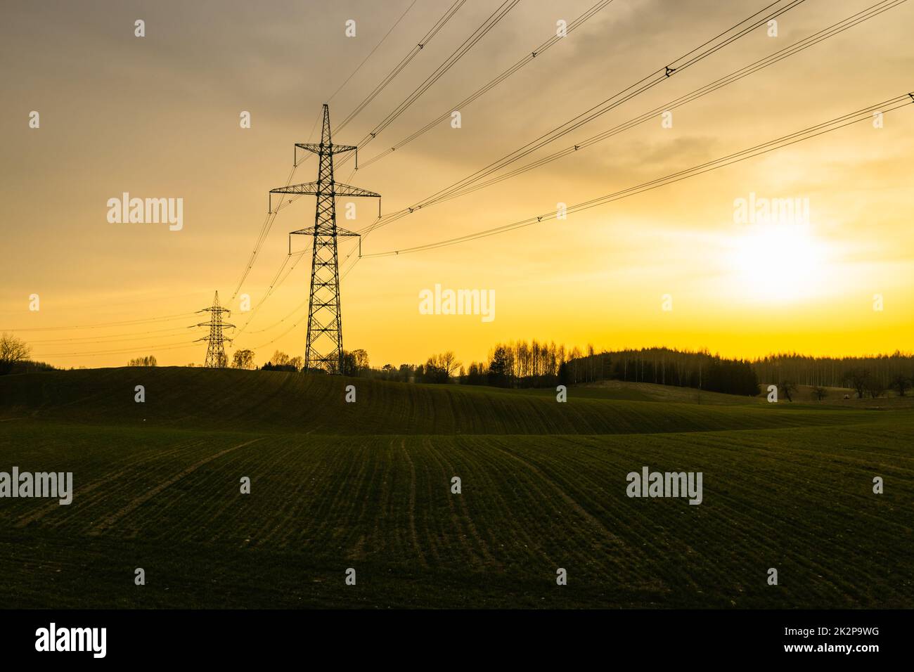 Hochspannungsmast und Übertragungsleitungen bei Sonnenuntergang Stockfoto