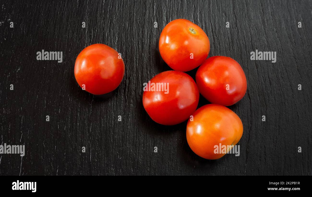 Frische Tomaten schwarzen Tisch Stockfoto