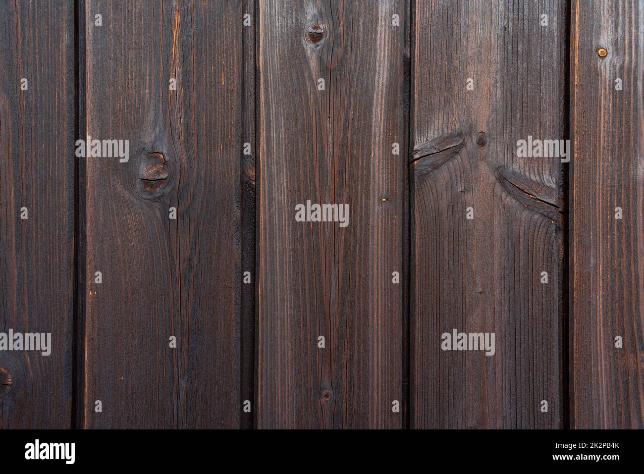 Alte braune ländliche Holzwand auf einem Balkon in dunklen Farben, detaillierte Bildtextur. Natürliche Holzkonstruktion, Hintergrund. Geeignet als Flatlay. Stockfoto