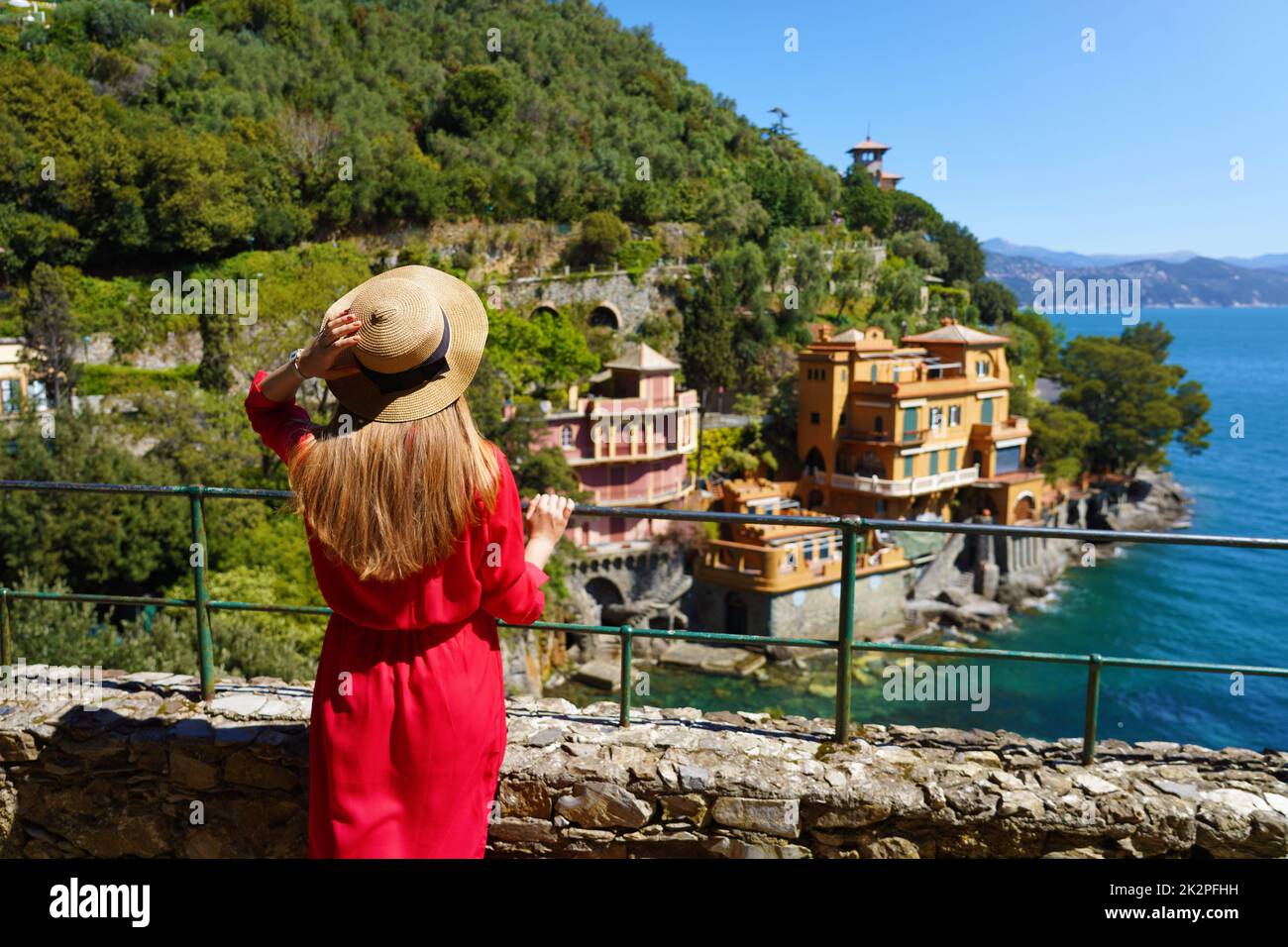 Schöne stilvolle Frau in rotem Kleid Blick auf die Bucht in Portofino, Italien Stockfoto