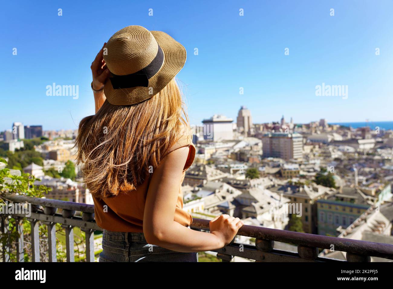 Tourismus in Genua, Italien. Rückansicht des jungen Reisenden Mädchens, das das Stadtbild von Genua von der Aussichtsterrasse aus genießt. Stockfoto