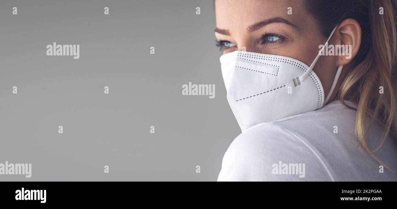 Junge Frau mit Gesichtsmaske während des Coronavirus- und Grippeausbruchs. Schutz vor Viren und Krankheiten, Quarantäne zu Hause. COVID-19-Konzept Stockfoto