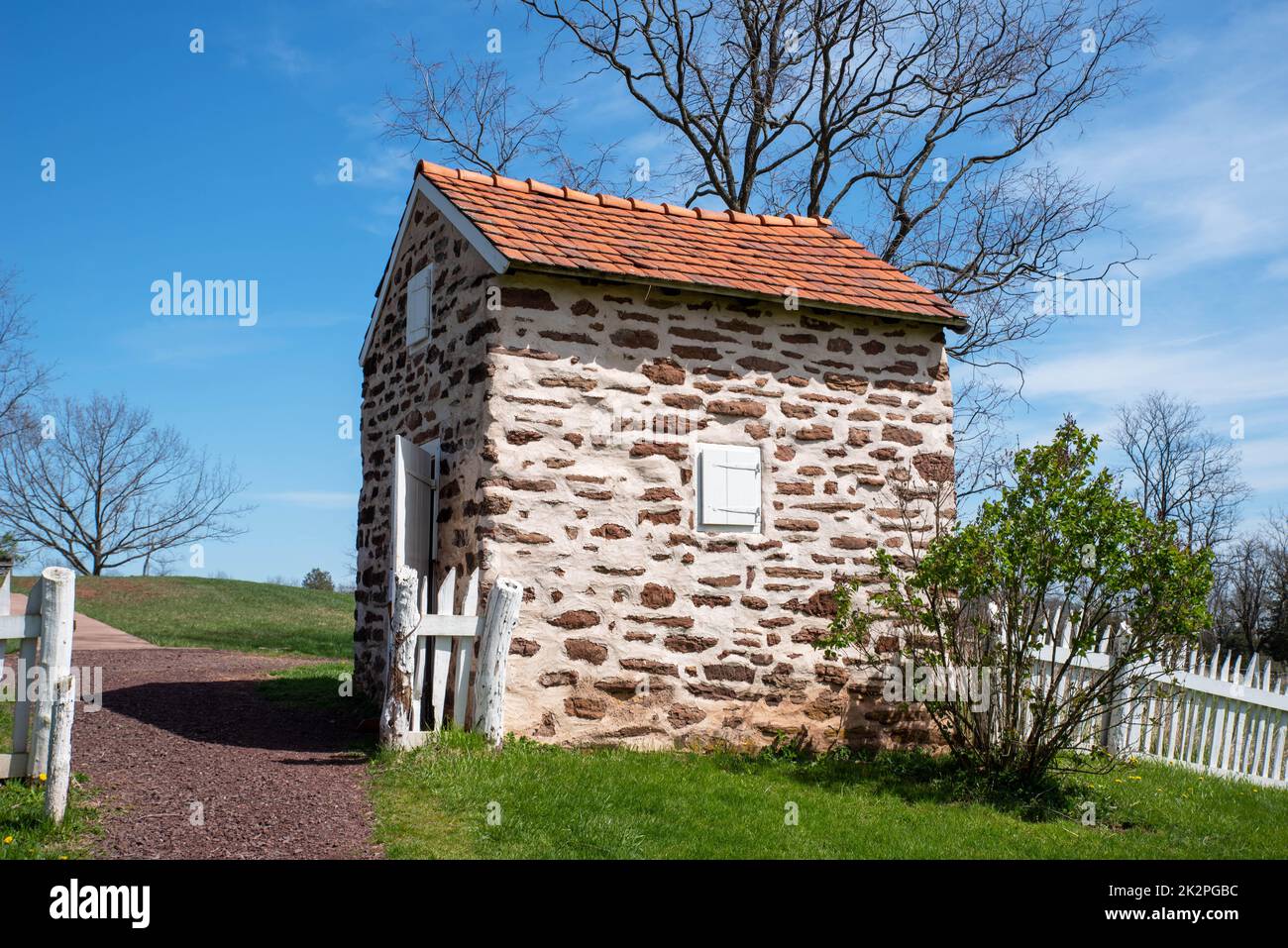 Koloniales amerikanisches Räucherhaus aus aus Stein in idyllischer Landschaft Stockfoto