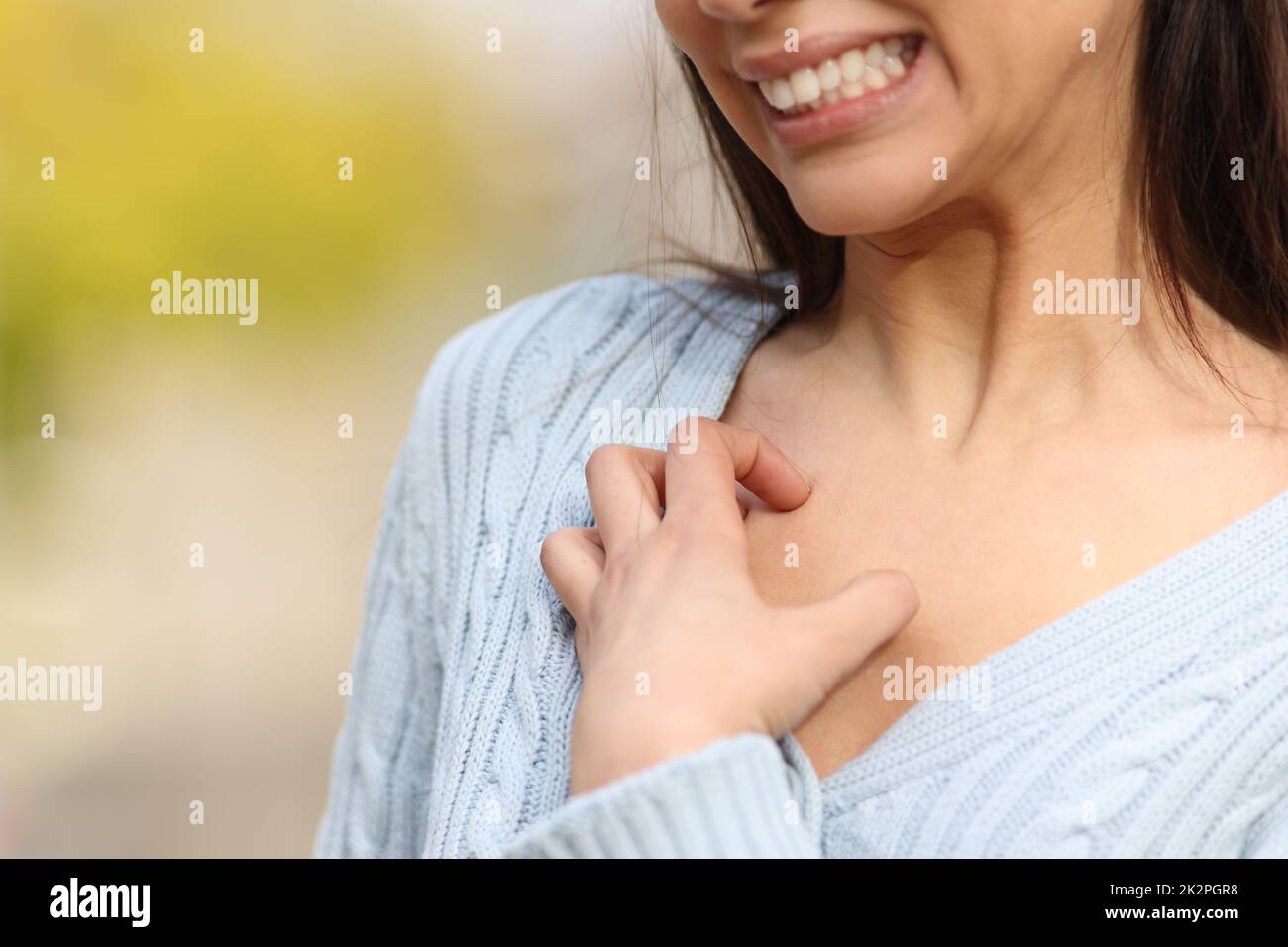 Gestresste Frau kratzt juckende Brust Stockfoto