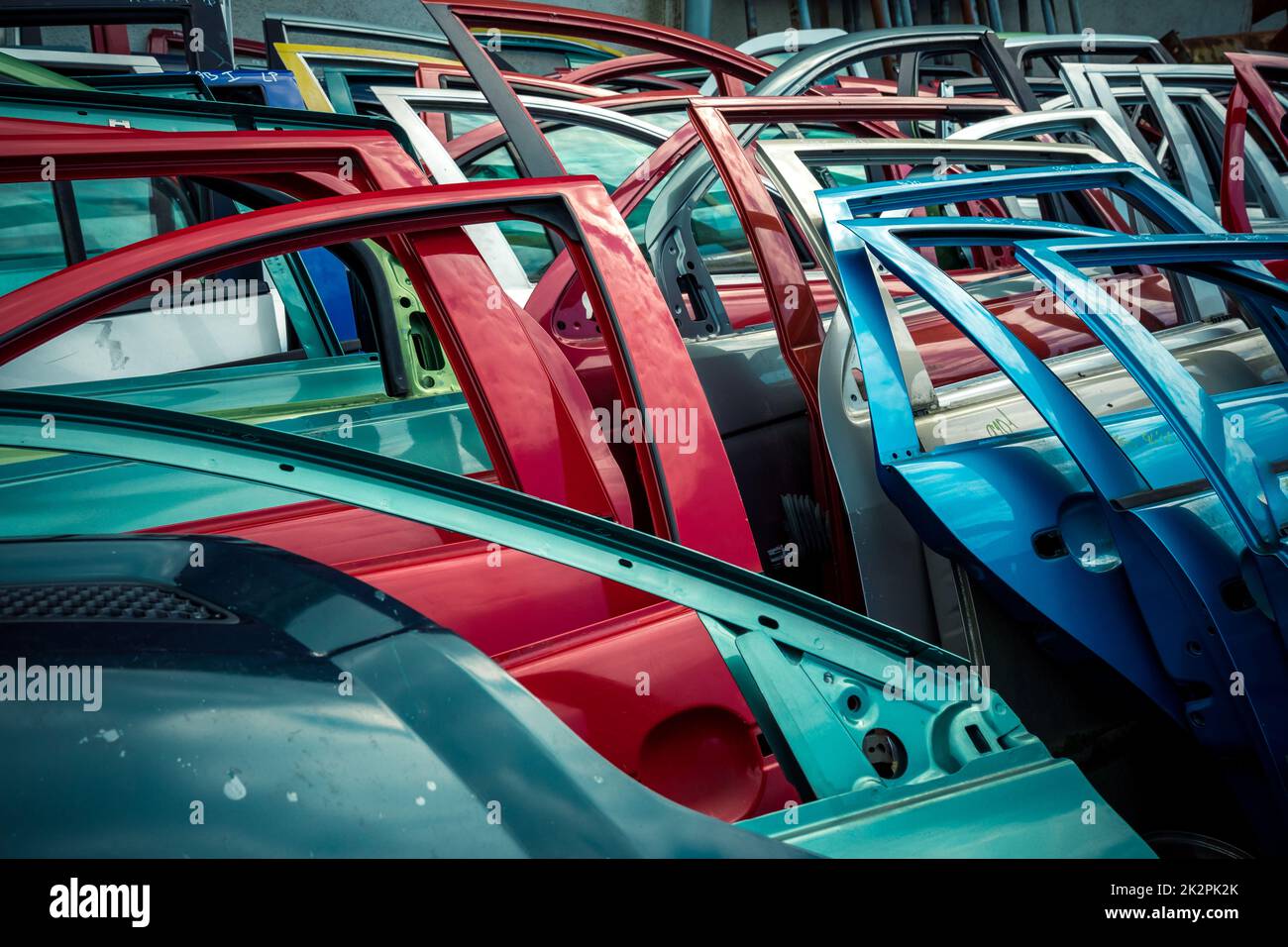 Verschiedene farbige Autotüren auf einem Autoschrottplatz Stockfoto
