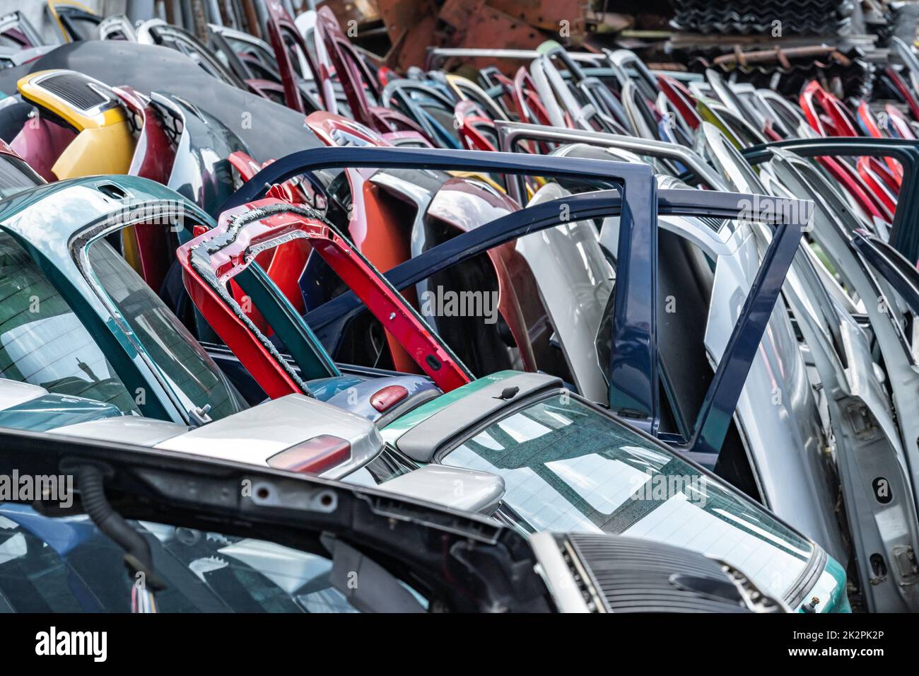 Verschiedene farbige Autotüren auf einem Autoschrottplatz Stockfoto