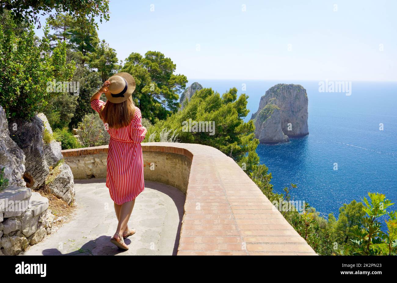 Stilvolle weibliche Reisende, die den Weg entlang mit spektakulärer Landschaft von Capri, Neapel, Italien, gehen Stockfoto
