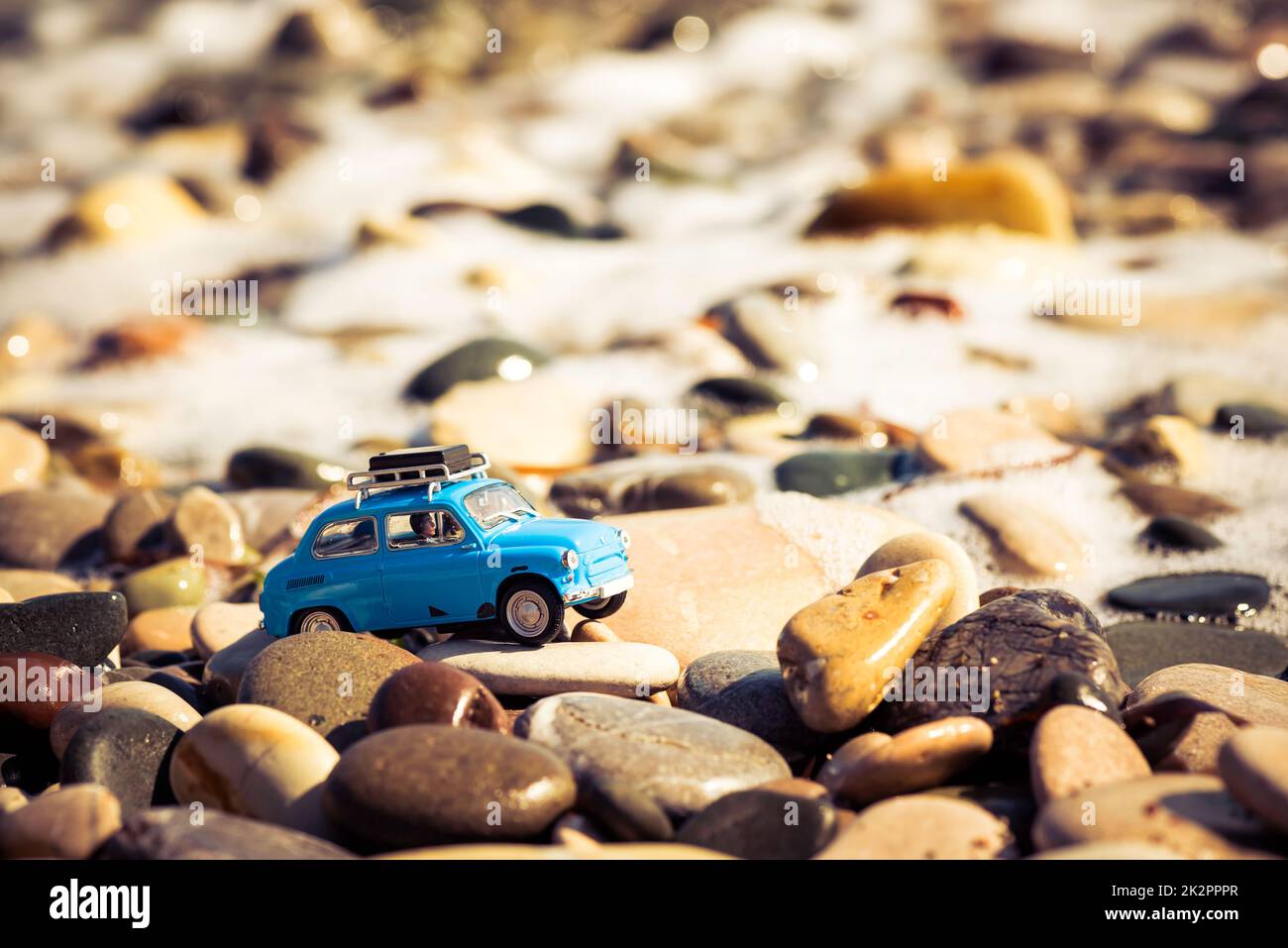 Oldtimer-Spielzeugauto am Strand. Reise- und Abenteuerkonzept Stockfoto
