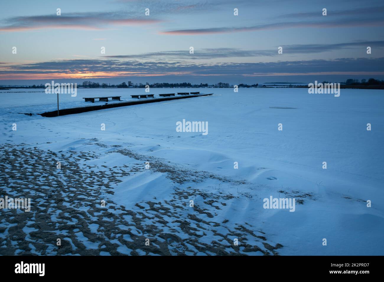 Schnee auf einem gefrorenen See bei Sonnenuntergang Stockfoto