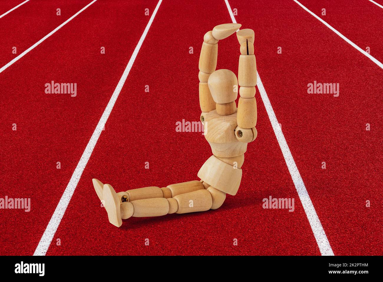 Ein Holzsportler, der bauchmuskeln macht, setzt sich zusammen Stockfoto