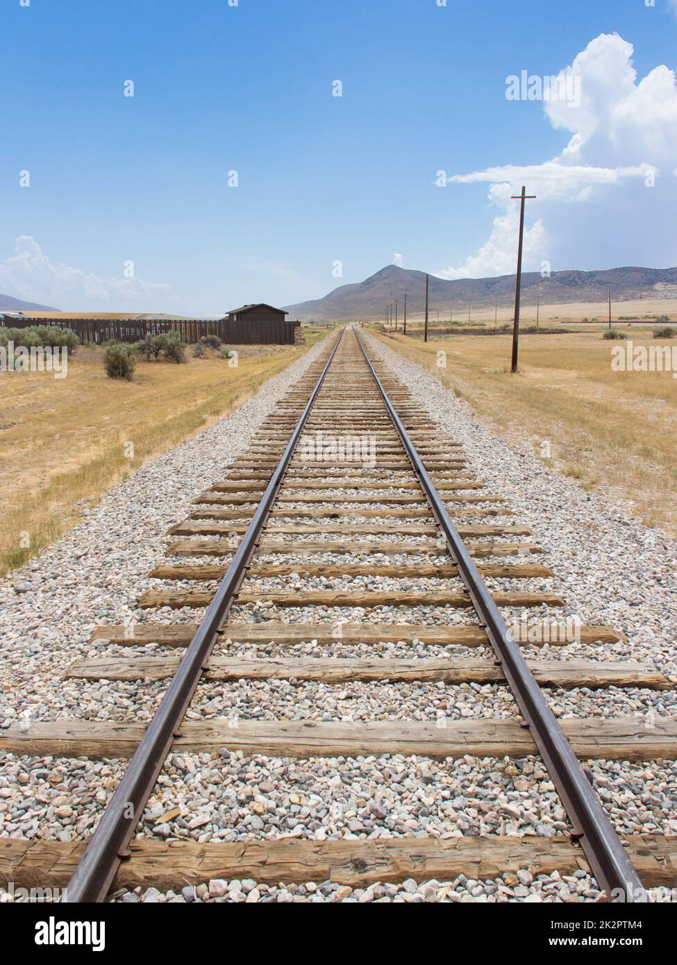 Die Eisenbahn in der Wüste. Perspektivischer Look mit blauem Himmel hinten. Stockfoto