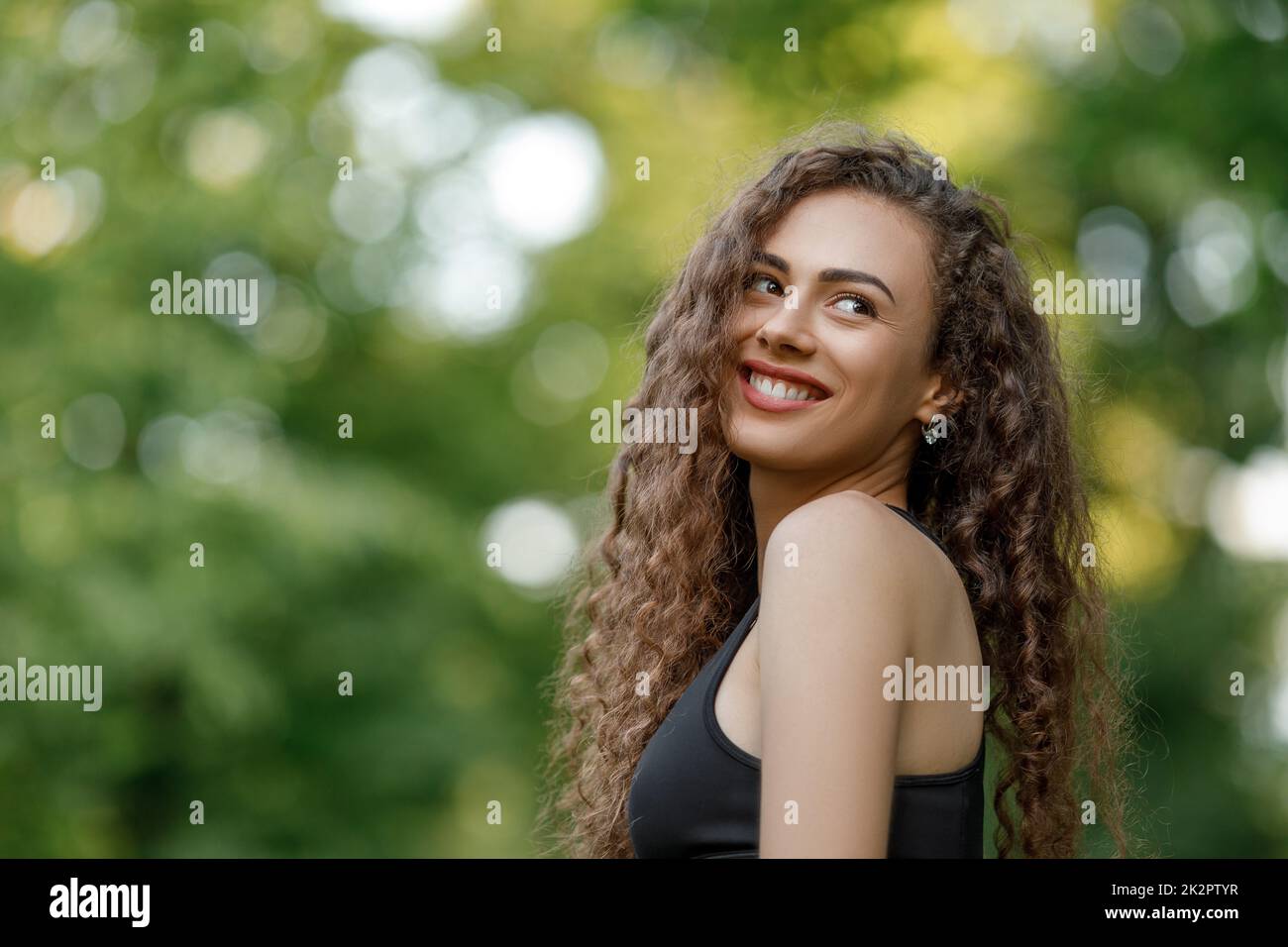 Curly schön lächelnde Frau Stockfoto