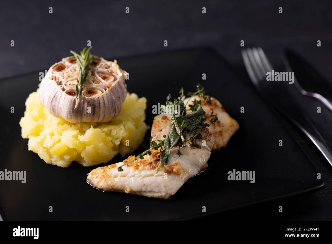 Kabeljaufilet mit Couscous und geröstetem Knoblauch Stockfoto