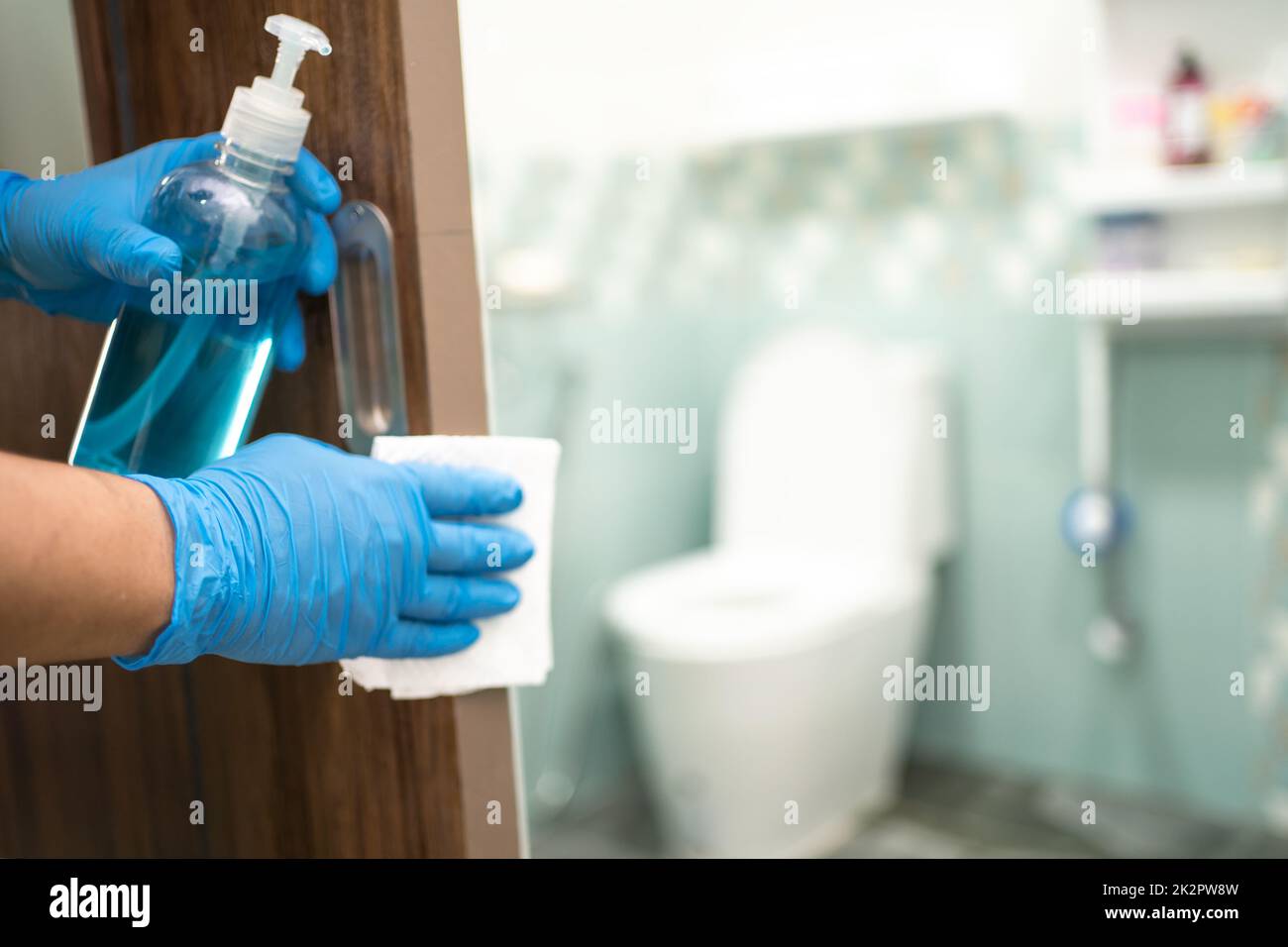 Reinigung Tür toliet Griff auf der Toilette mit Alkohol und Gewebe im Büro und zu Hause zum Schutz covid 19 Coronavirus Stockfoto