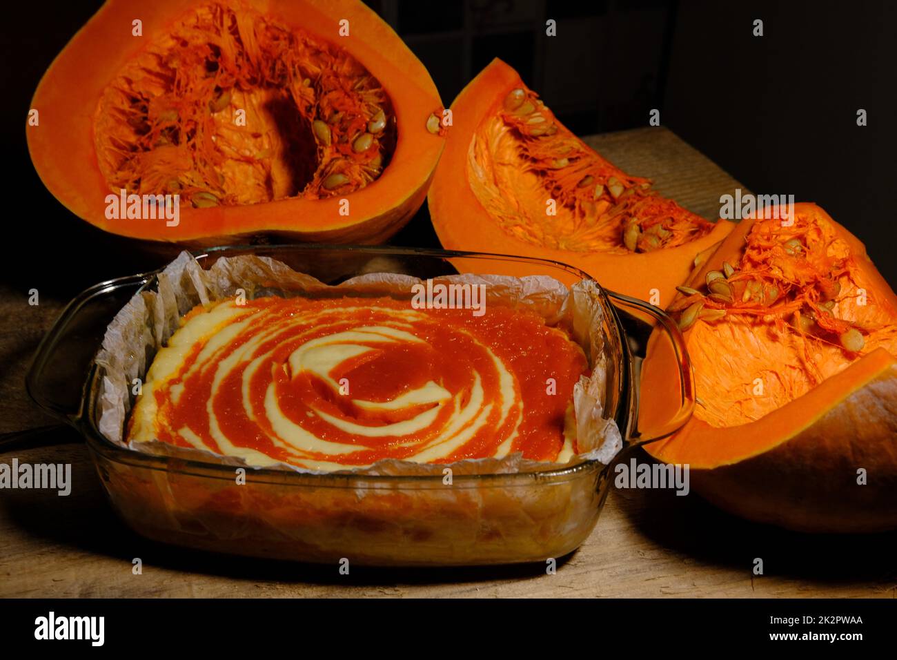 Hausgemachter Kürbiskuchen Käsekuchen mit einem Stück Kürbis. Orangendessert. SEITENANSICHT Stockfoto