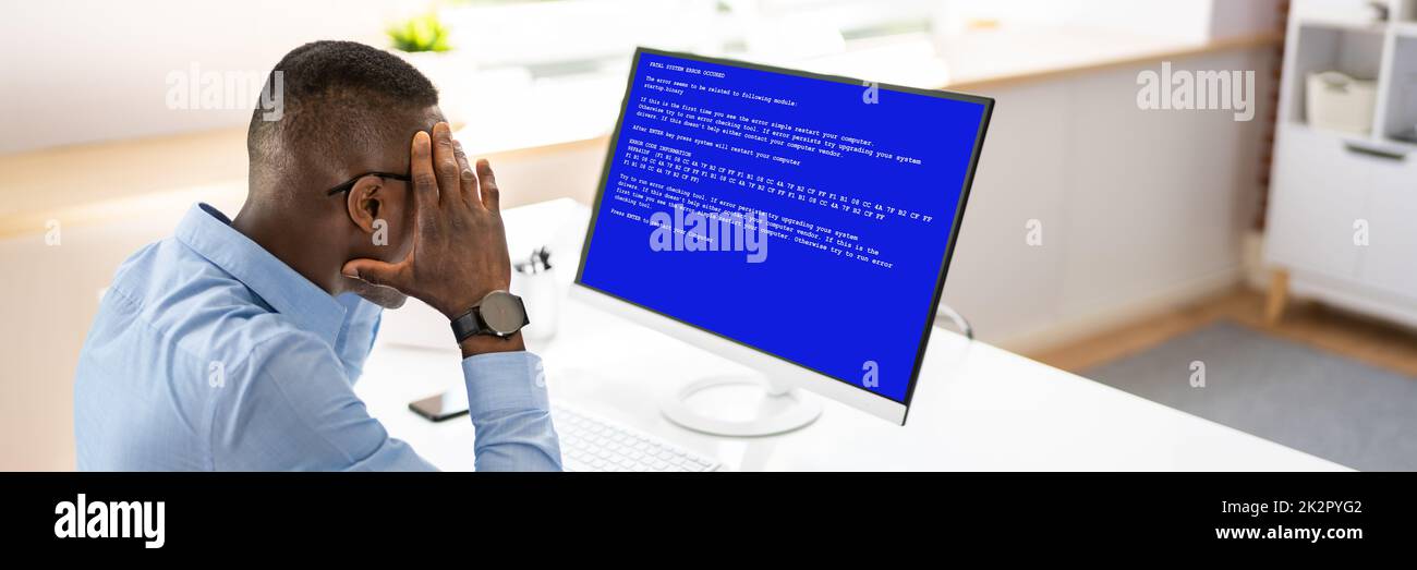 Besorgter Mann Am Computer Mit Systemausfall Auf Dem Bildschirm Stockfoto