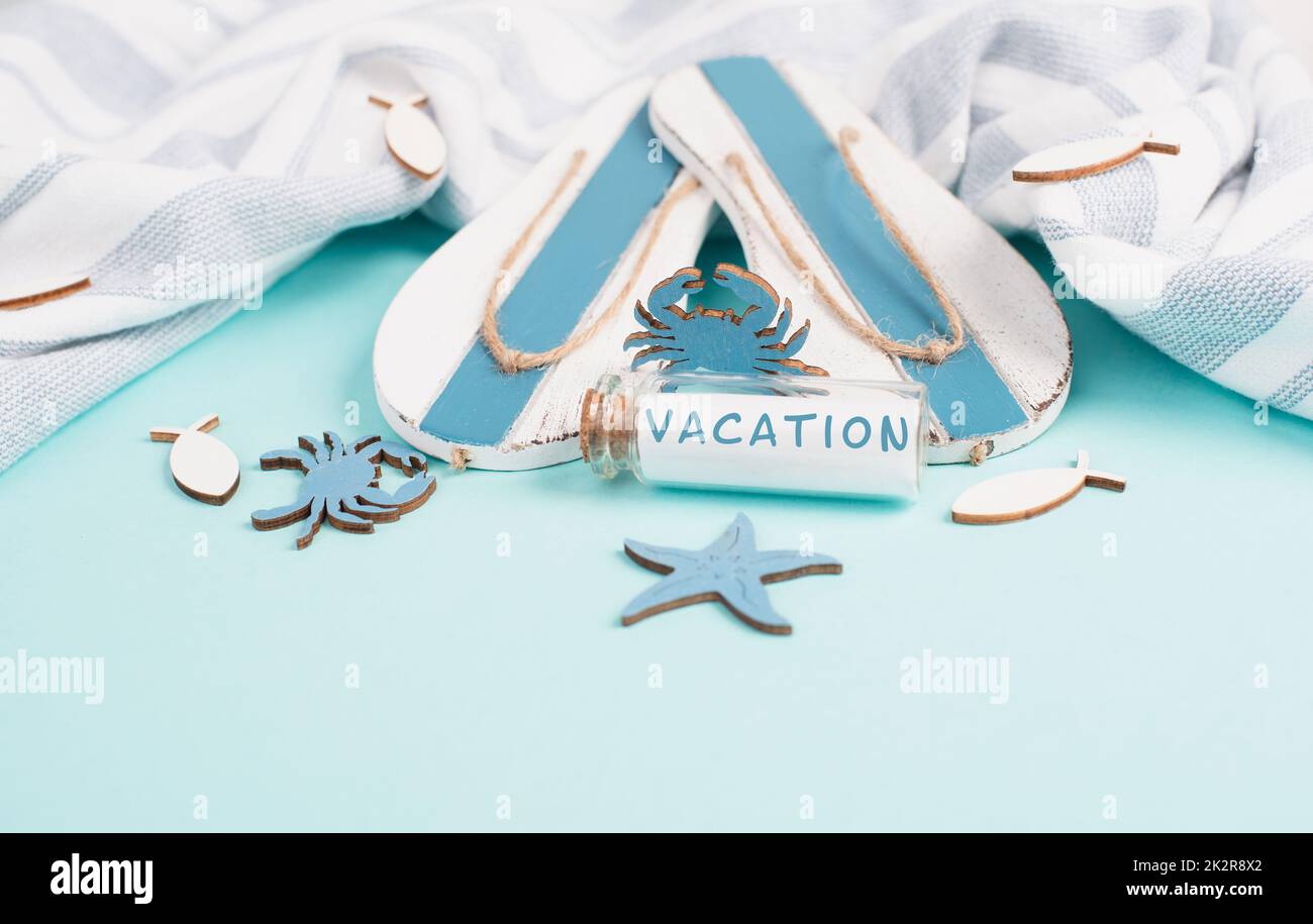 Blauer Sommer- und Urlaubshintergrund, Flossen, Seesterne und ein Glas bootle mit dem Wort Urlaub, Reise- und Tourismuskonzept Stockfoto