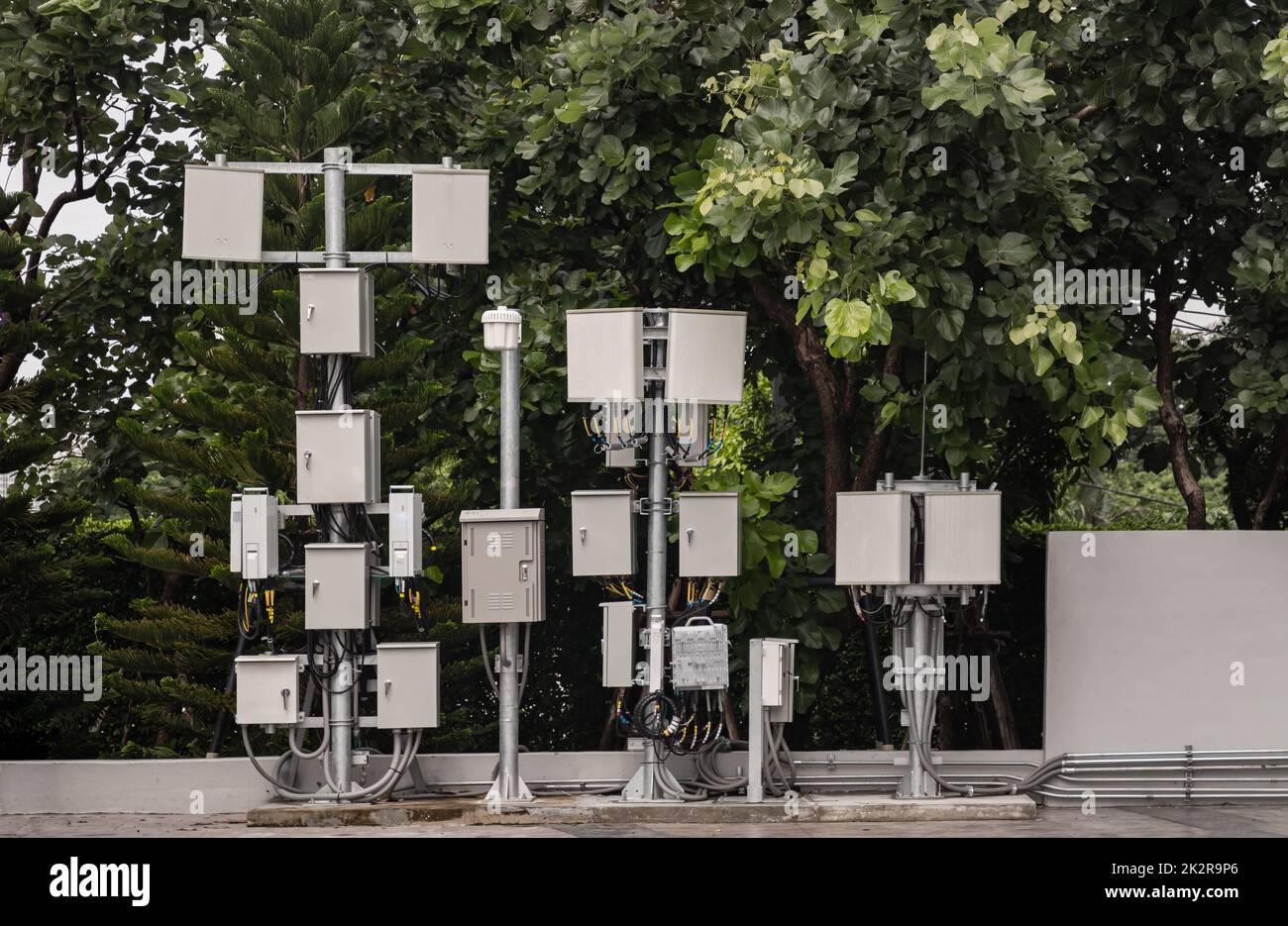 Viele Kommunikationsverteiler mit Kabeldrähten für den Anschluss von Telefon- oder Internetsignalen befinden sich auf einer Stahlsäule vor dem Hintergrund von gree Stockfoto
